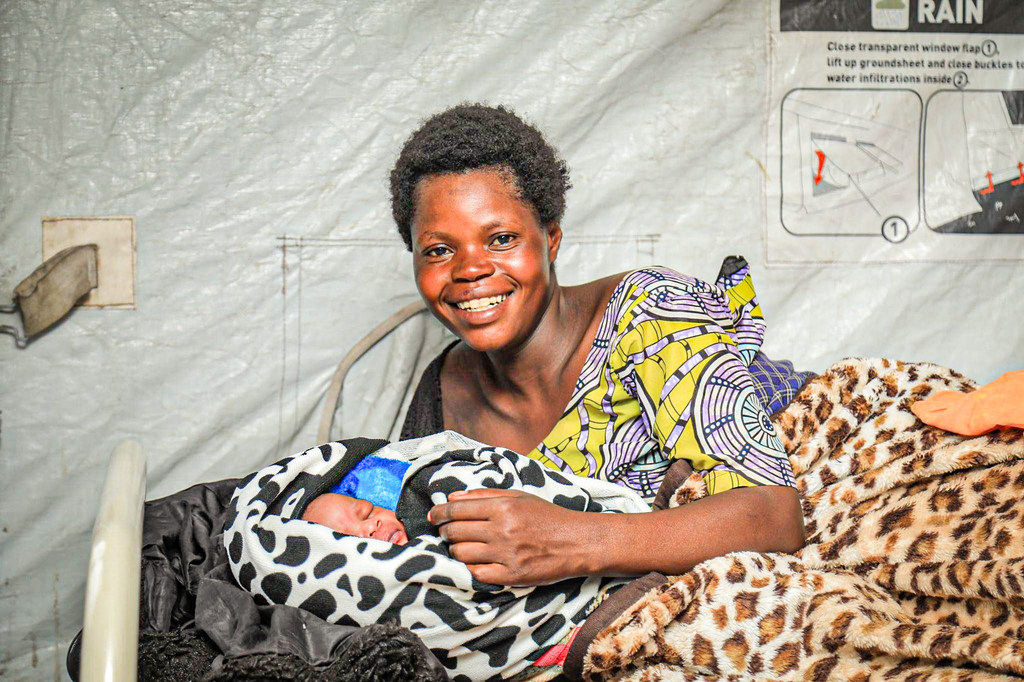 Francine Toyata anamlea bintiye mchanga Amani katika kliniki tembezi ya afya, mojawapo ya kliniki zinazoungwa mkono na UNFPA nchini DR Congo.