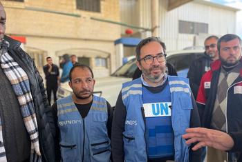UN Assistant Secretary-General and Executive Director of UNOPS, Mr. Moreira da Silva, stands outdoors in Gaza with colleagues wearing UNOPS vests.
