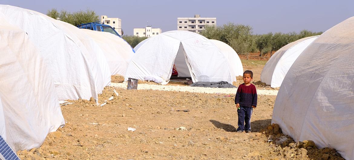 सीरिया के पश्चिमोत्तर इलाक़े में, हाल ही में विस्थापित हुए लोगों के लिए बनाए गए एक शिविर में खड़ा एक बच्चा.