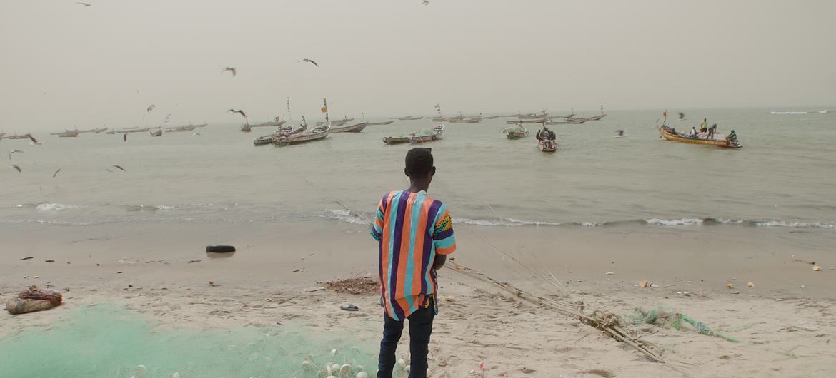 Amadou Jobe, emigrante retornado, mirando al océano Pacífico desde la costa de Gambia.
