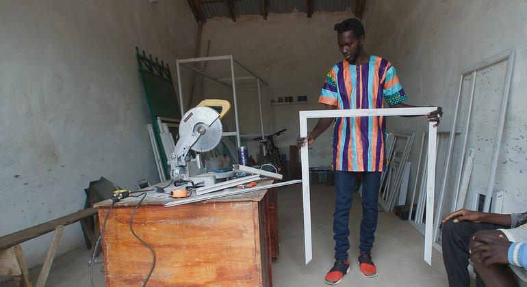 Amadou Jobe, seorang migran yang kembali, telah mendapatkan pekerjaan di ibu kota Gambia, Banjul.