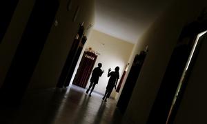 Two young girls walk through the corridor to attend a psychosocial group session.