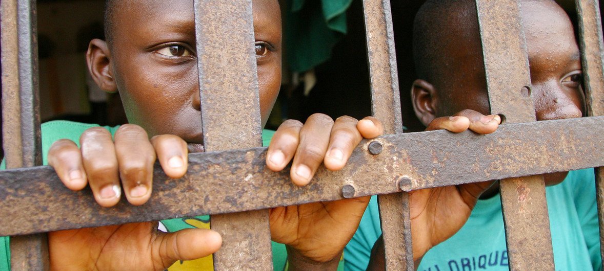 Deux jeunes prisonniers derrière les barreaux d'une prison à Abomey, au Bénin.