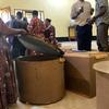 Watu wanachunguza kifaa cha kuwekea kuku cha mviringo wakati wa maonyesho kuhusu ufugaji wa kuku nchini Tanzania.