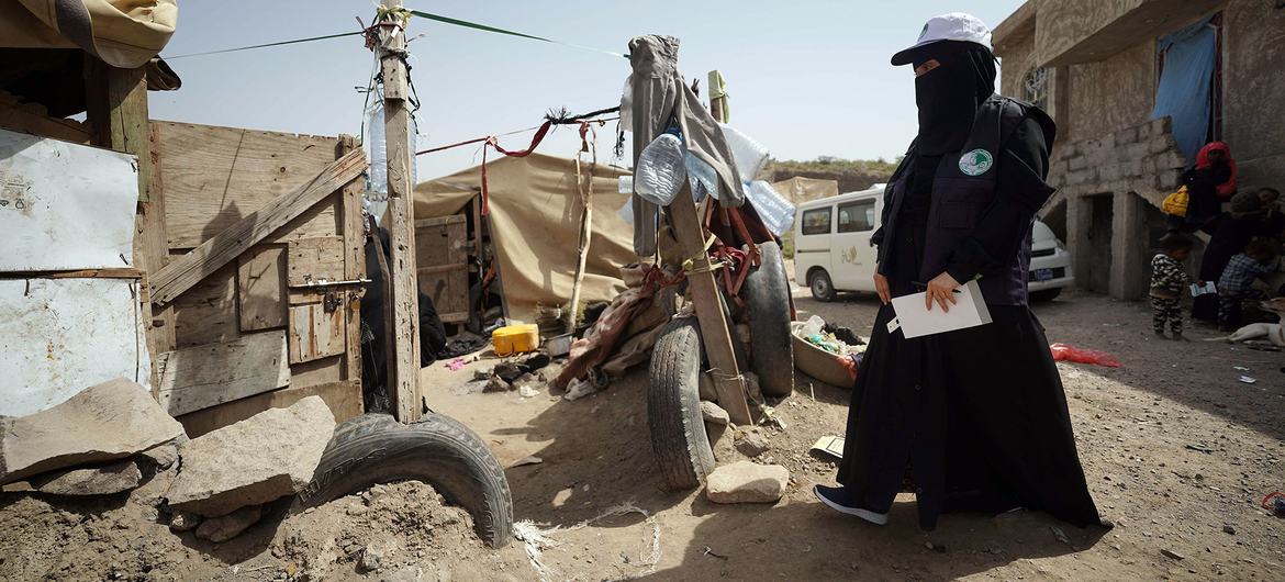 Years of conflict have left thousands across Yemen dependent on humanitarian assistance. Pictured here, a health volunteer walks in an IDP camp to check on malnourished children.