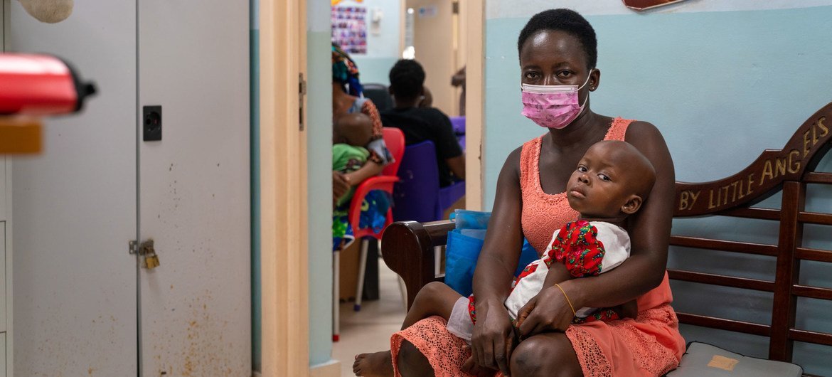 घाना में एक माँ और उसकी बेटी, उपचार के लिए एक अस्पताल में अपनी बार की प्रतीक्षा करते हुए.