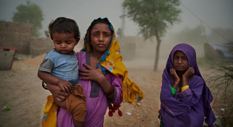 Família em vilarejo que foi gravemente afetado pelas enchentes no Paquistão
