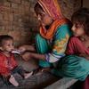 पाकिस्तान में बाढ़ प्रभावित इलाक़े में कुपोषण का शिकार एक बच्चे को उसकी माँ खाना खिला रही है.