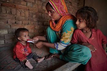 طفل صغير يعاني من سوء التغذية تطعمه والدته في المنزل الواقع بقرية دمرتها الفيضانات في باكستان.