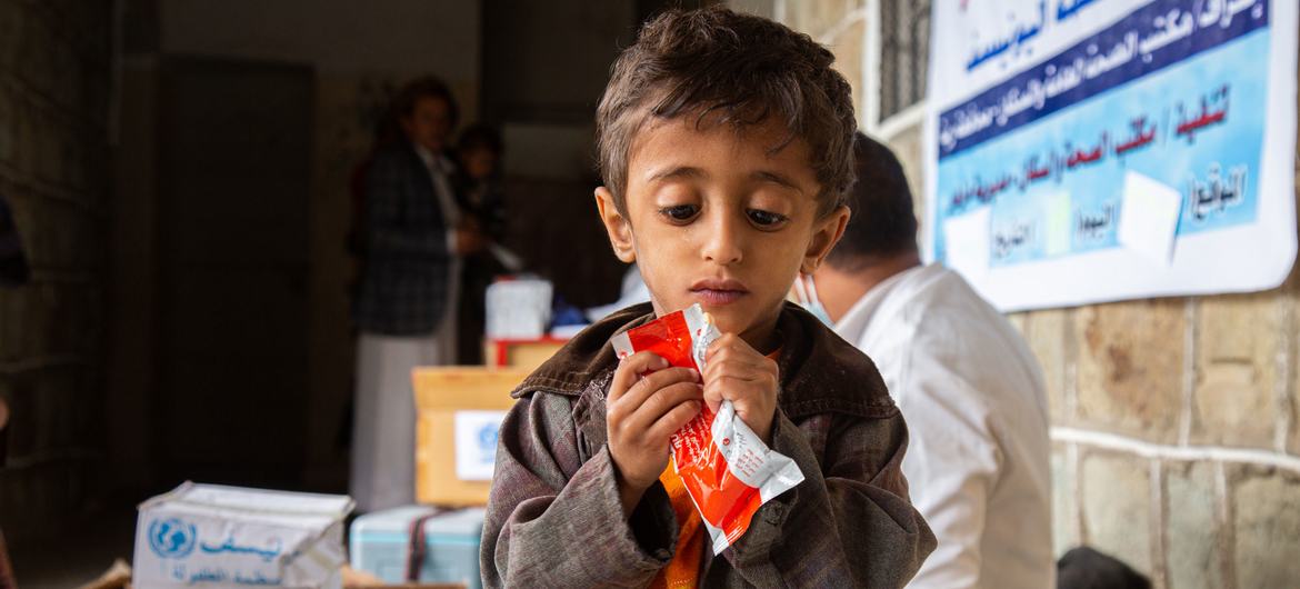 A young malnourished boy in Yemen eats the Ready-to-Use Therapeutic Food (RUTF).