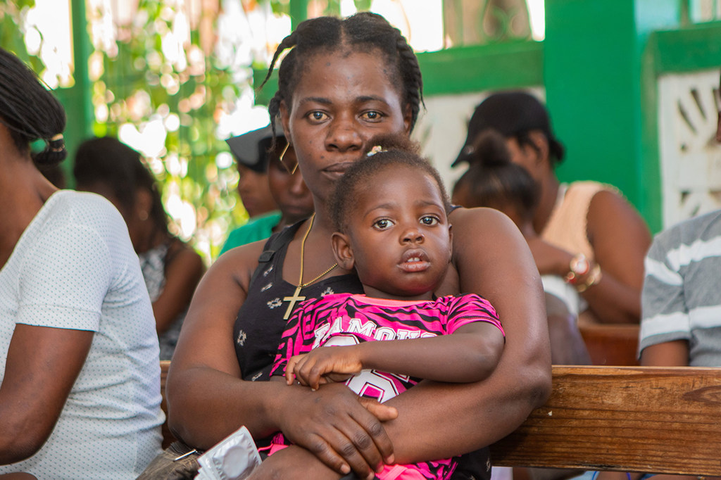 母亲和孩子们在海地南部一家人口基金支持的医院等待接种疫苗。