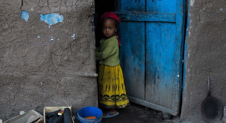 Une fille se tient devant sa maison dans la région du Tigré, en Éthiopie.
