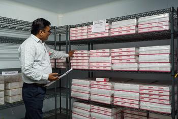 स्टोर में वॉक-इन कूलर के भीतर पीसीवी टीके का स्टॉक जाँचते हुए मंसूरी .