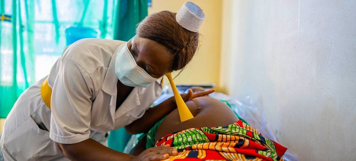 یک پرستار یک مادر باردار را در حین ویزیت دوران بارداری در یک مرکز بهداشتی در اوگاندا معاینه می کند.