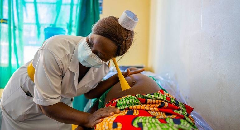 ممرضة تقوم بفحص أم حامل أثناء زيارة رعاية ما قبل الولادة في مركز صحي في أوغندا.