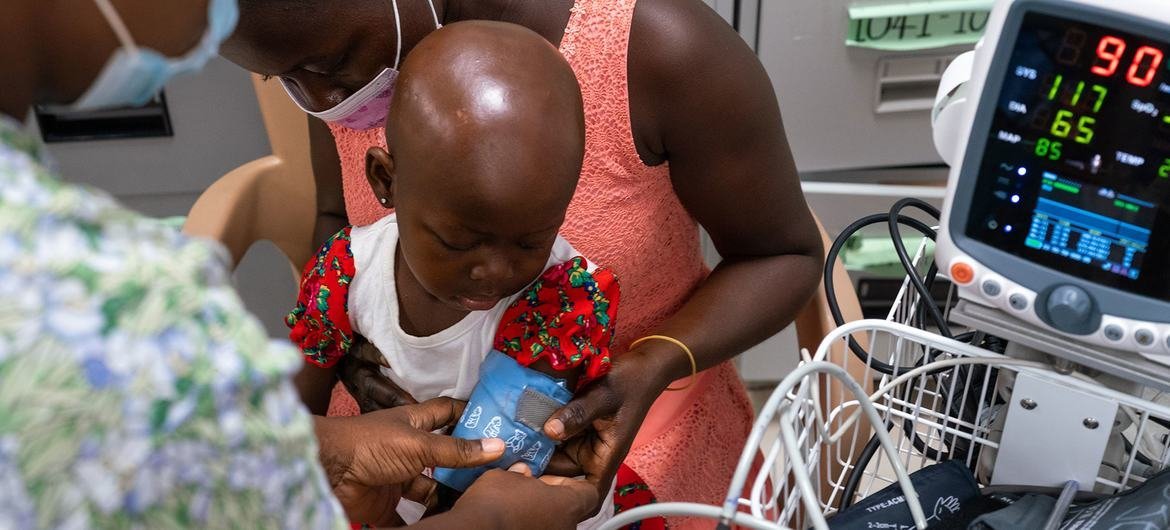 在加纳的一家医院，一名患有癌症的两岁女孩正在接受一名护士的体检。 