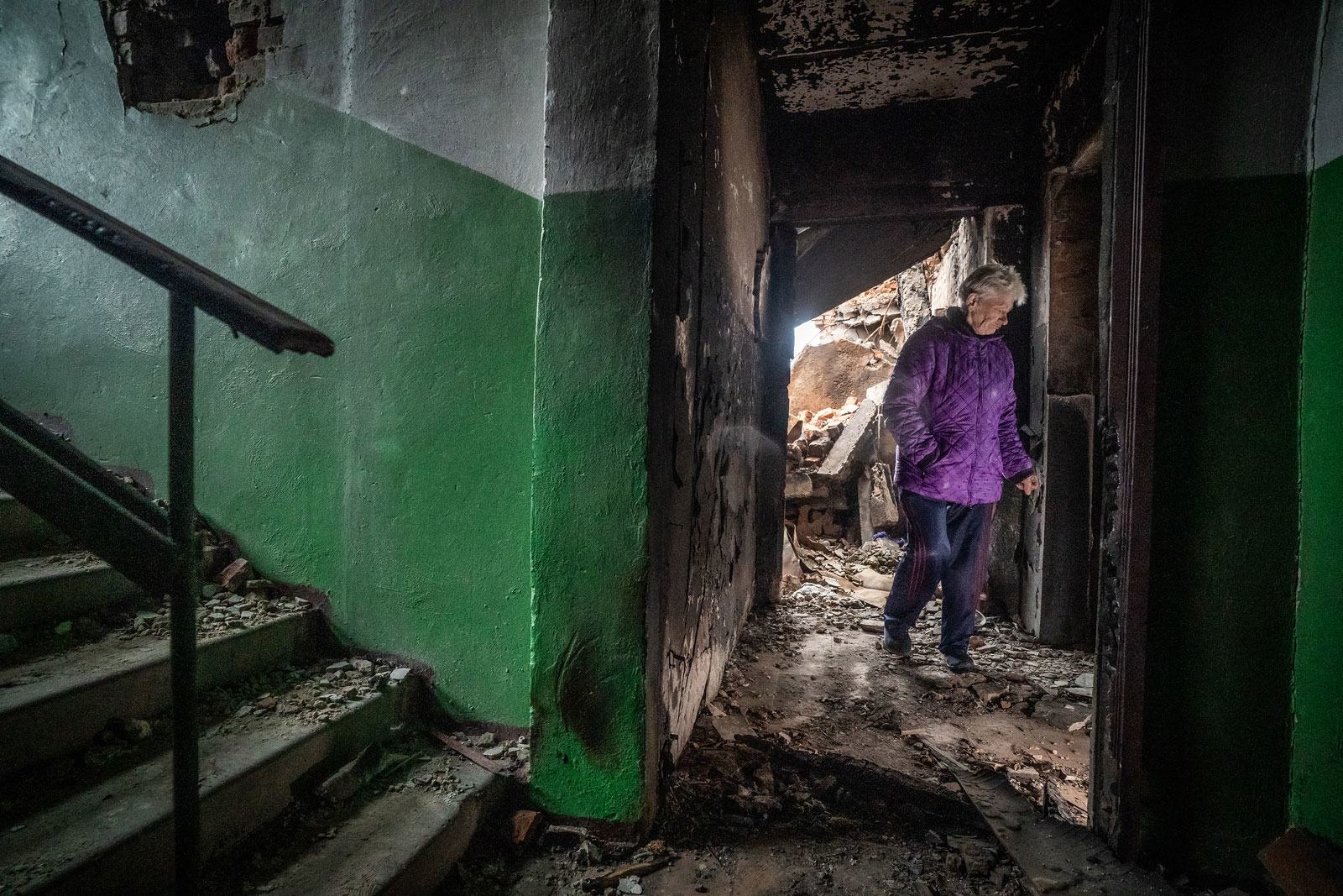 在乌克兰哈尔科夫斯卡市，一名妇女看着她公寓里散落的瓦砾。