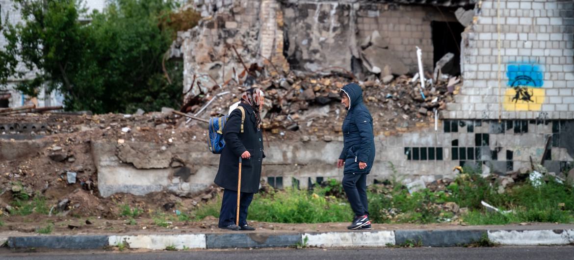 نساء يتحدثن خارج مبنى سكني تضرر من الغارات الجوية في بلدة بورودينكا بضواحي كييف.