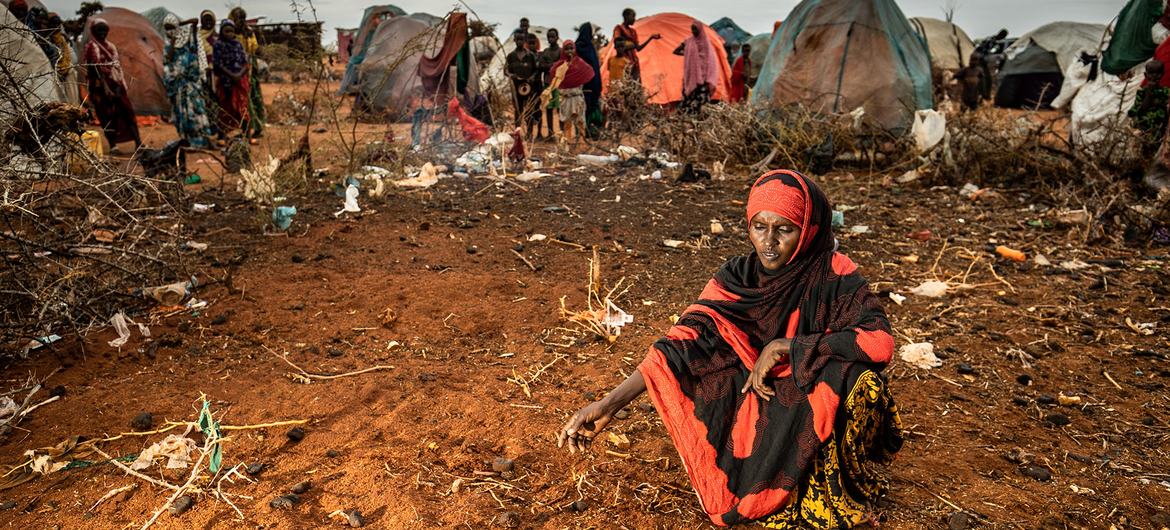 Une mère est assise devant les tombes anonymes de ses deux jeunes enfants dans un camp de personnes déplacées à Dollow, en Somalie.