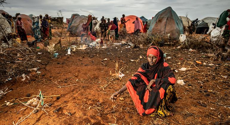 सोमालिया में एक महिला, अपने दो छोटे बच्चों की मौत के बाद उनकी क़ब्र के पास बैठे हुए.