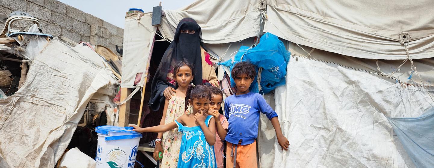 Une famille déplacée reçoit des articles de secours sur un site dans le gouvernorat de Lahaj, au Yémen.
