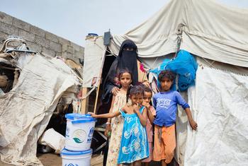 Une famille déplacée reçoit des articles de secours sur un site dans le gouvernorat de Lahaj, au Yémen (photo d'archives).