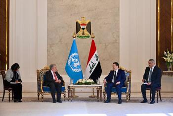 UN Secretary-General Antonio Guterres meets with Iraqi Prime Minister Mohammed Al-Sudani in a formal diplomatic meeting, seated opposite each other with UN and Iraqi flags between them.