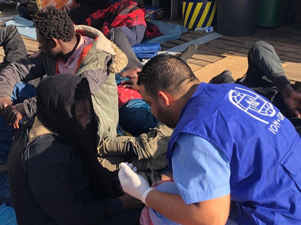 Wahamiaji ambao wamerejeshwa pwani ya Libya baada ya kufunga safari kupitia bahari kuelekea Ulaya wakipokelewa na wafanyakazi wa IOM.