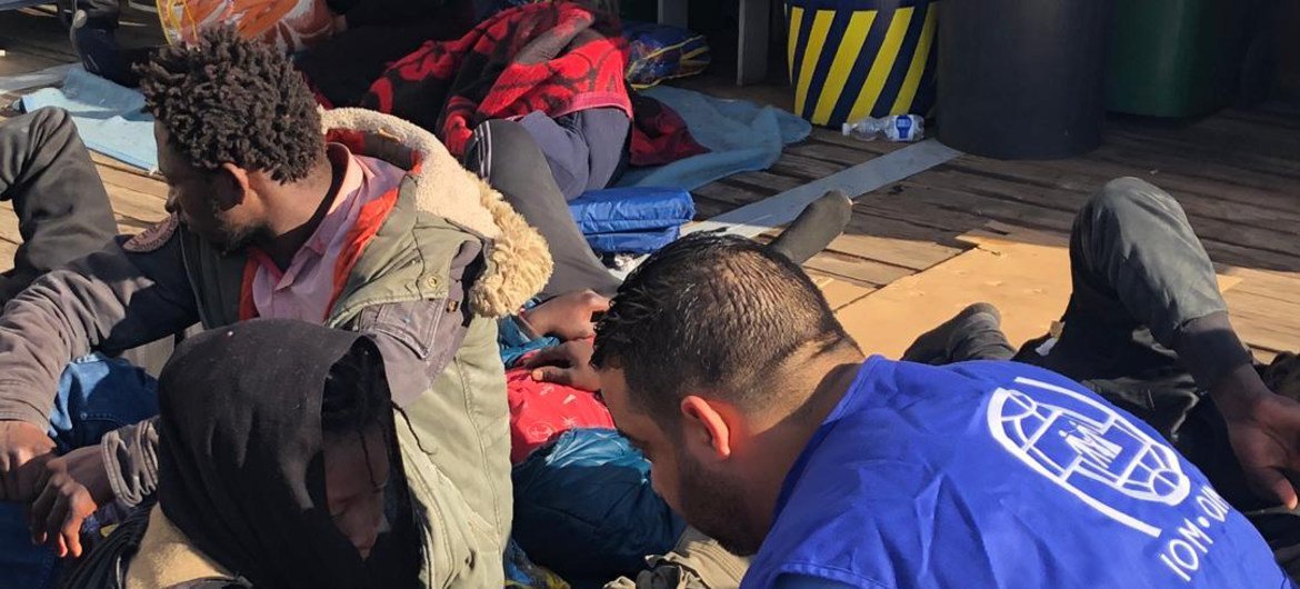 Migrantes que fueron devueltos a tierra en Libia tras intentar cruzar el mar para llegar a Europa reciben el apoyo de trabajadores humanitarios de la OIM (foto de archivo). 