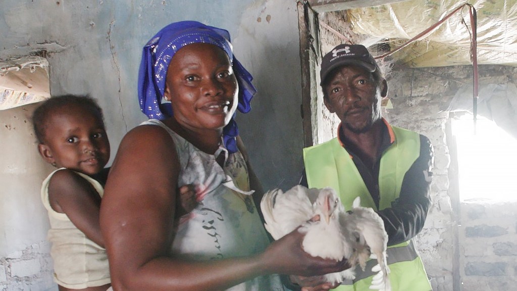 A customer buys a chicken from Guidom Sabally's poultry farm in rural Gambia