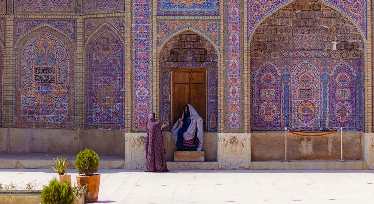 Dos personas frente a un edificio en Irán.