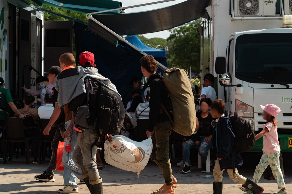 Personas desplazadas, cargadas con mochilas y bolsos, llegan al estadio General Santander de Cúcuta para recibir ayuda humanitaria.