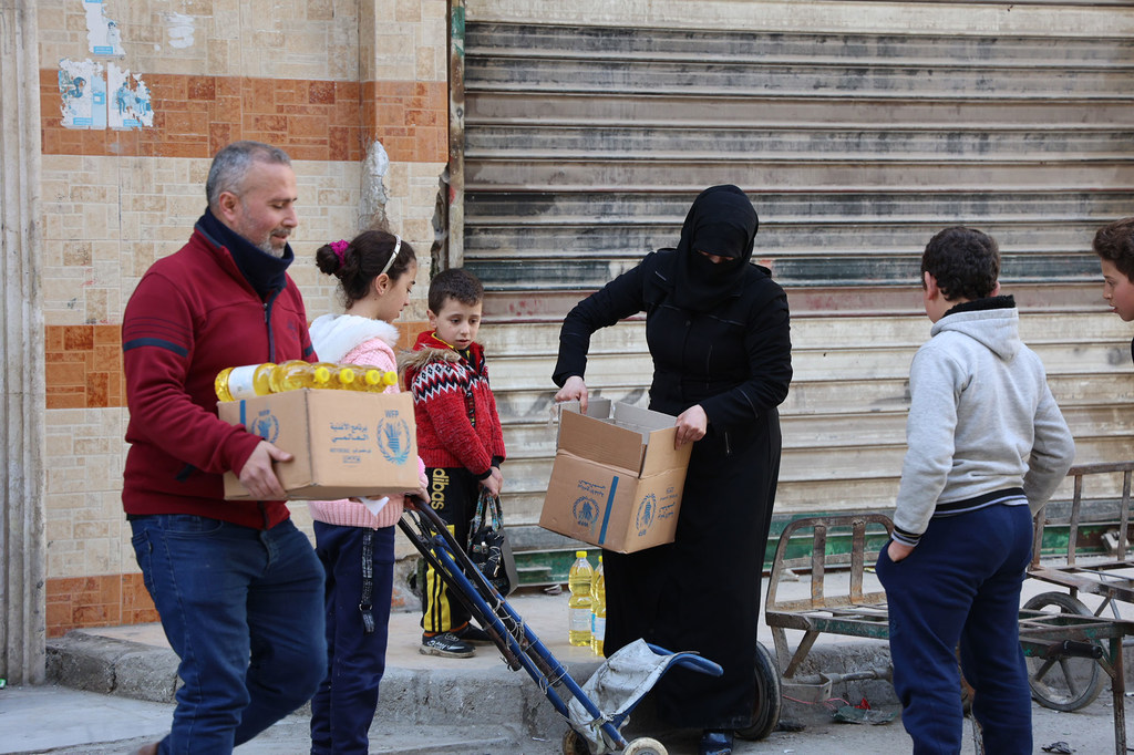 Des rations alimentaires mensuelles sont distribuées aux familles déplacées dans le quartier de Sukari à Alep, en Syrie.