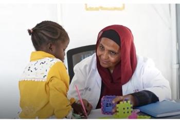 Amal, mtaalamu wa afya ya akili katika kliniki inayofadhiliwa na UNICEF kwenye jimbo la Kassala, mashariki mwa Sudan, akizungumza na mtoto Walaa mwenye umri wa miaka minne ambaye anakabiliwa na changamoto ya afya ya akili kutokana na vita inayoendelea nc…