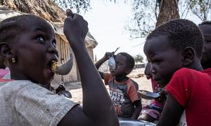 Children in Fangak county, Jonglei State eat a cooked meal of sorghum. WFP provides food rations to food insecure families containing sorghum, oil, salt, peas and maize. .South Sudan 20 January 2022.