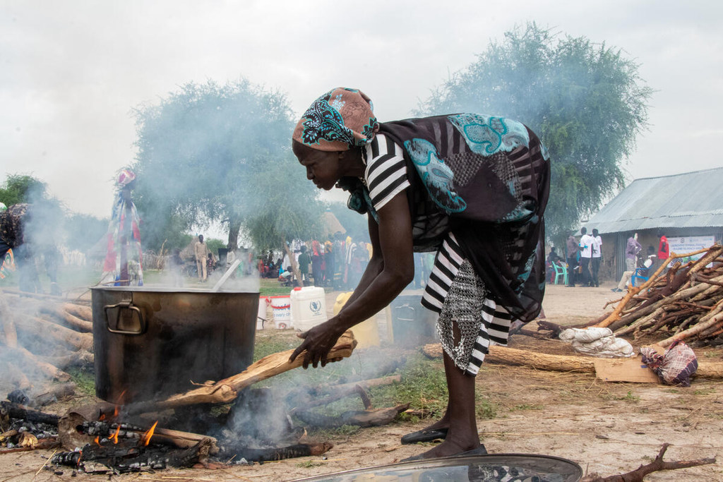Una mujer sursudanesa cocina comidas escolares en una olla grande sobre fuego abierto en Akobo West, estado de Jonglei, Sudán del Sur.