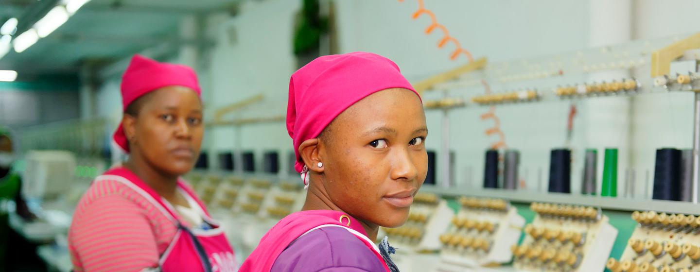 Des ouvrières de l'habillement se tiennent à côté d'une ligne de machines à coudre dans une usine de vêtements au Lesotho.