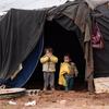 在叙利亚南部的一个非正式营地中，流离失所儿童站在自家的帐篷前。