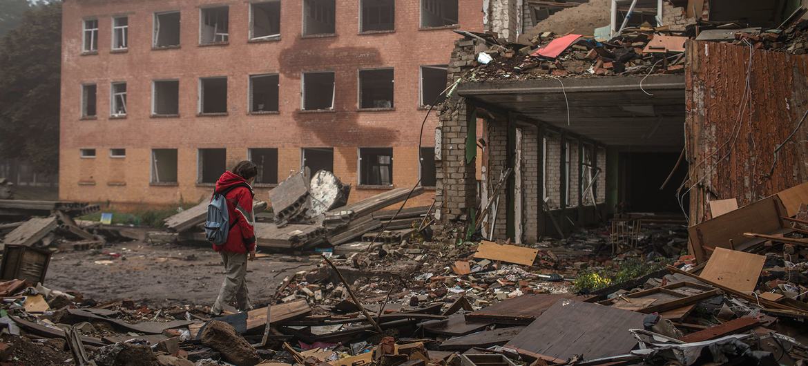 Uma menina caminha pelos escombros no pátio de uma escola destruída por um bombardeio em Chernihiv, na Ucrânia