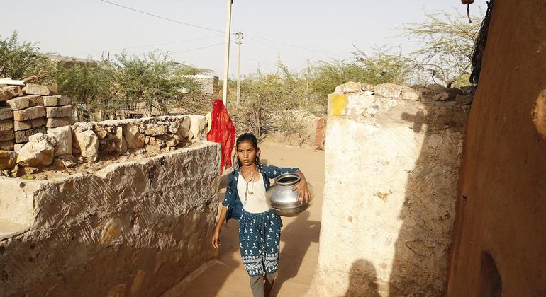भारत में राजस्थान के फलौदी ज़िले के सूखाग्रस्त क्षेत्र में स्थित कानासर गाँव की 10 वर्षीय नेमा, भंडारण टैंक से पानी भरकर ले जा रही हैं.