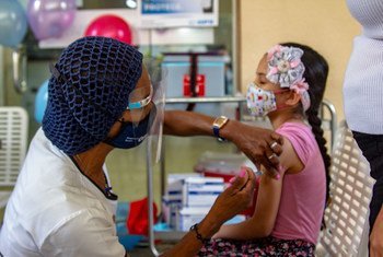 Una niña  es inmunizada durante una campaña de vacunacion en Venezuela.