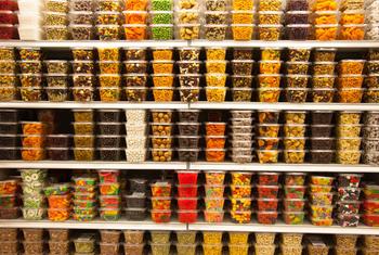 Contenedores con un surtido de caramelos en la estantería de una tienda.