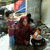 Khadija Manoun et sa fille dans une cuisine de fortune, à l'intérieur d'un bâtiment détruit.