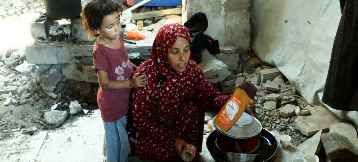 Khadija Manoun and her daughter in the space she uses as a kitchen inside a destroyed building.