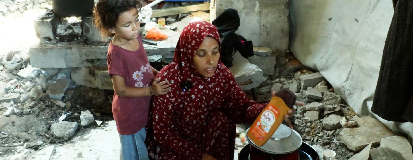 Khadija Manoun et sa fille dans une cuisine de fortune, à l'intérieur d'un bâtiment détruit.