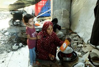 Khadija Manoun et sa fille dans une cuisine de fortune, à l'intérieur d'un bâtiment détruit.