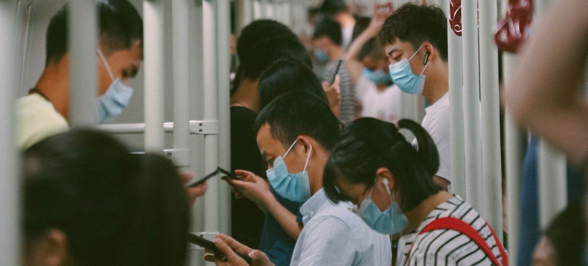 乘客们在广州地铁车厢内浏览手机。