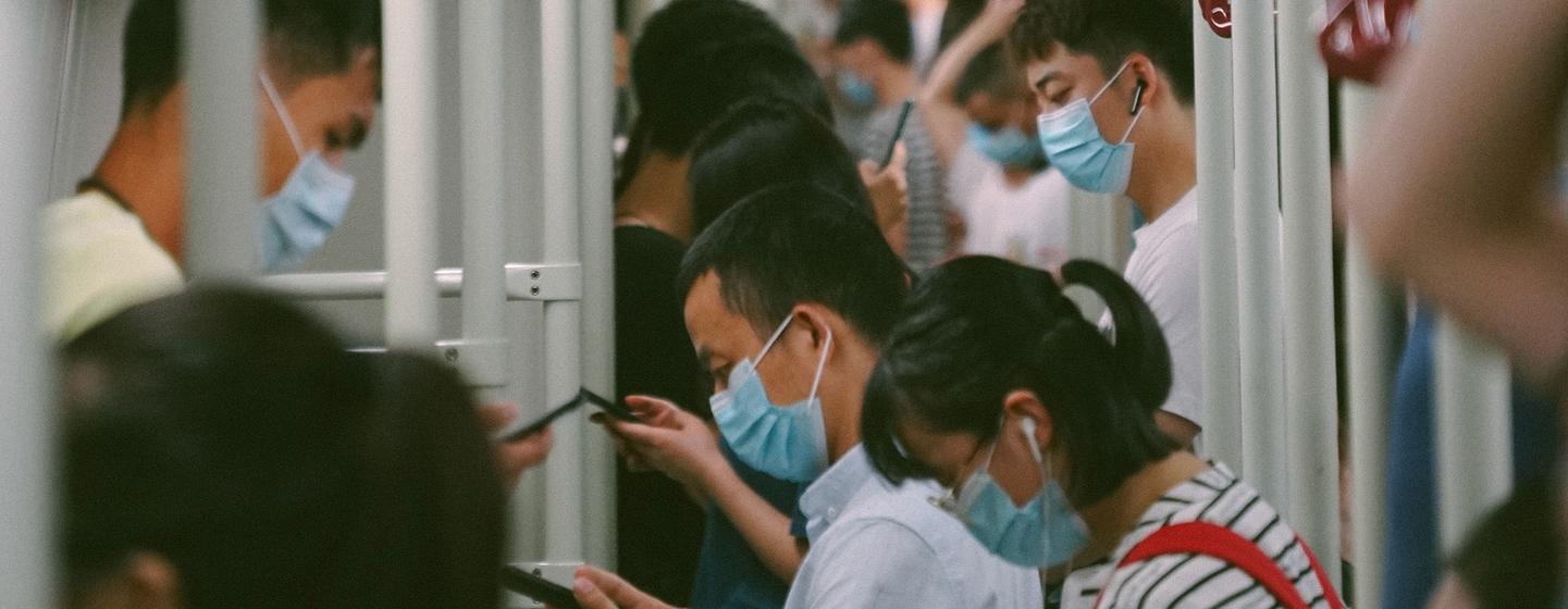 乘客们在广州地铁车厢内浏览手机。