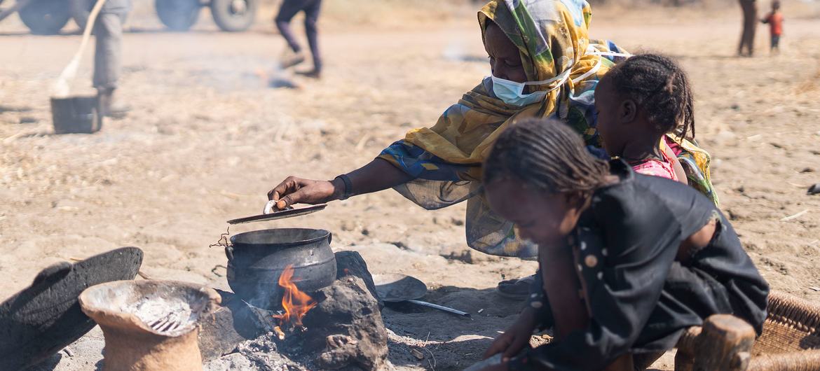 An internally displaced woman cooks in an open space in the El Ban Gadeed settlement in Sudan.