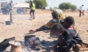 An internally displaced woman cooks in an open space in the El Ban Gadeed settlement in Sudan.